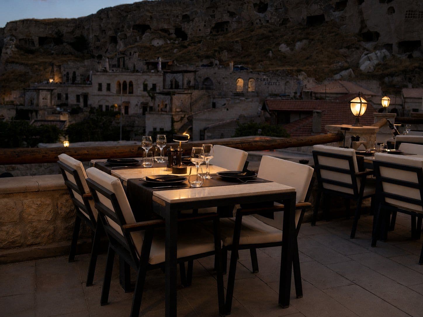 Gün batımında Solem Restaurant terasında kurulu bir masa, arkada mağara kayalıkları